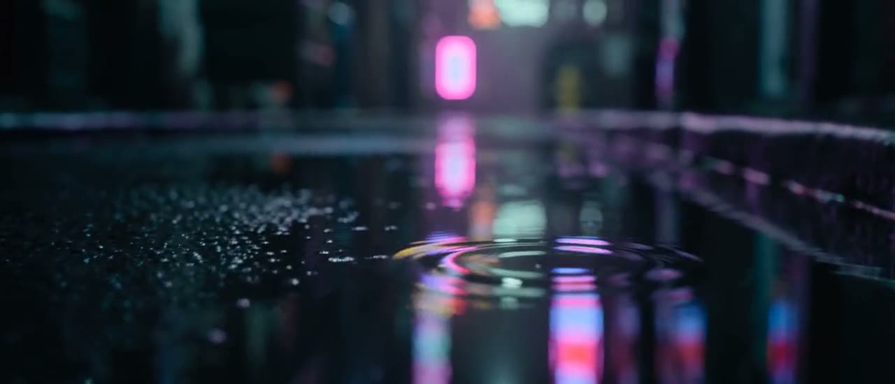 Frame del music video «Lanterns»: figura con lanterna sotto la pioggia al neon